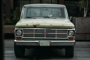 A vintage green ford pickup truck parked outside.