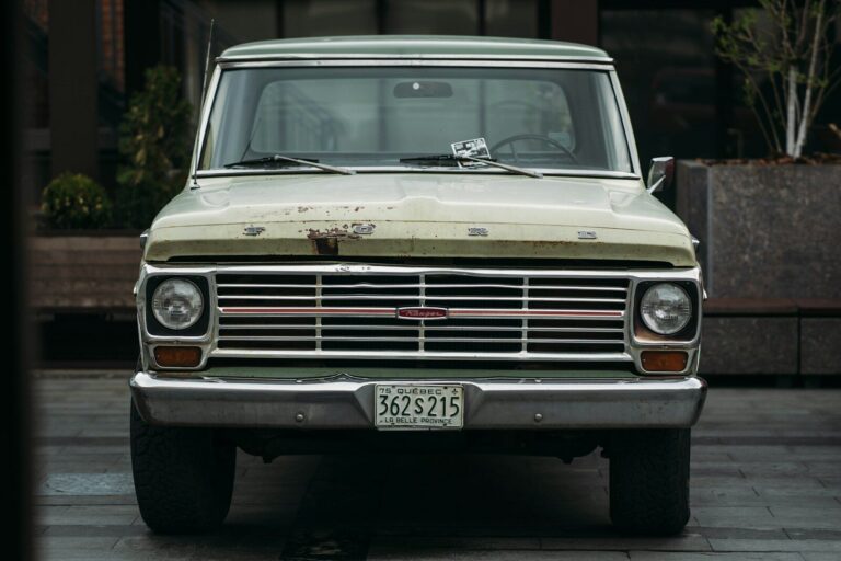 A vintage green ford pickup truck parked outside.