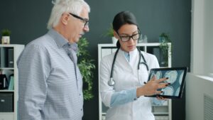 Doctor shows medical scan to elderly patient