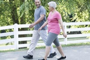 Older couple walking briskly outdoors
